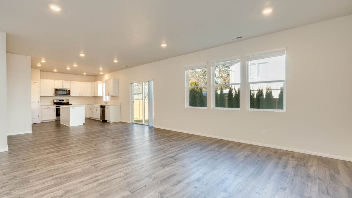 Eden Estates dining room with laminate flooring, windows, and the kitchen in the background
