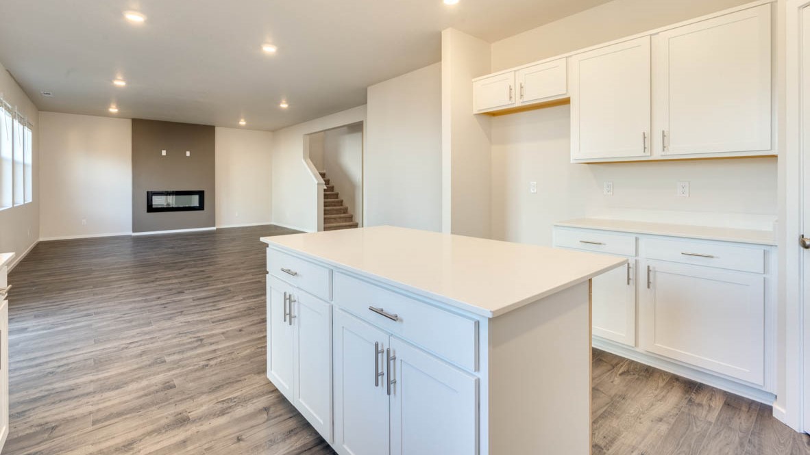 Eden Estates kitchen with laminate flooring, stainless steel appliances, cabinets, window, solid surface countertops