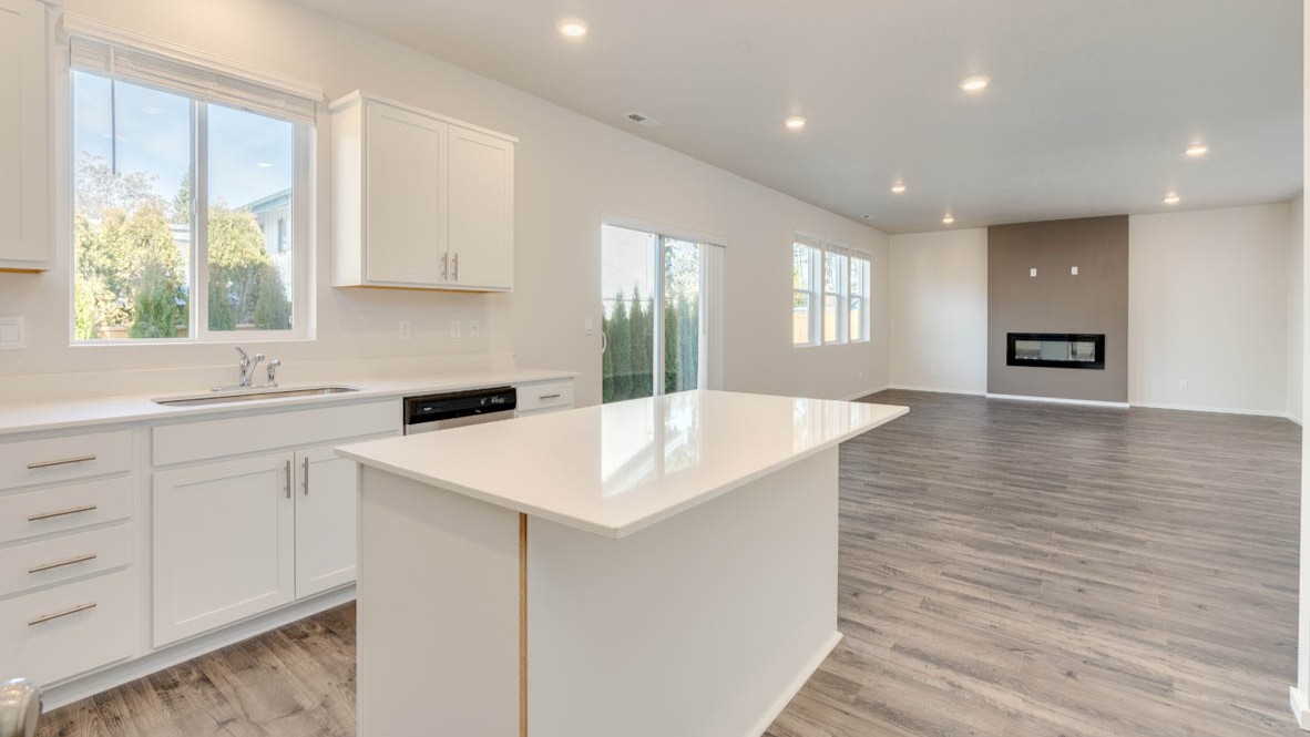 Eden Estates kitchen with laminate flooring, stainless steel appliances, cabinets, window, solid surface countertops