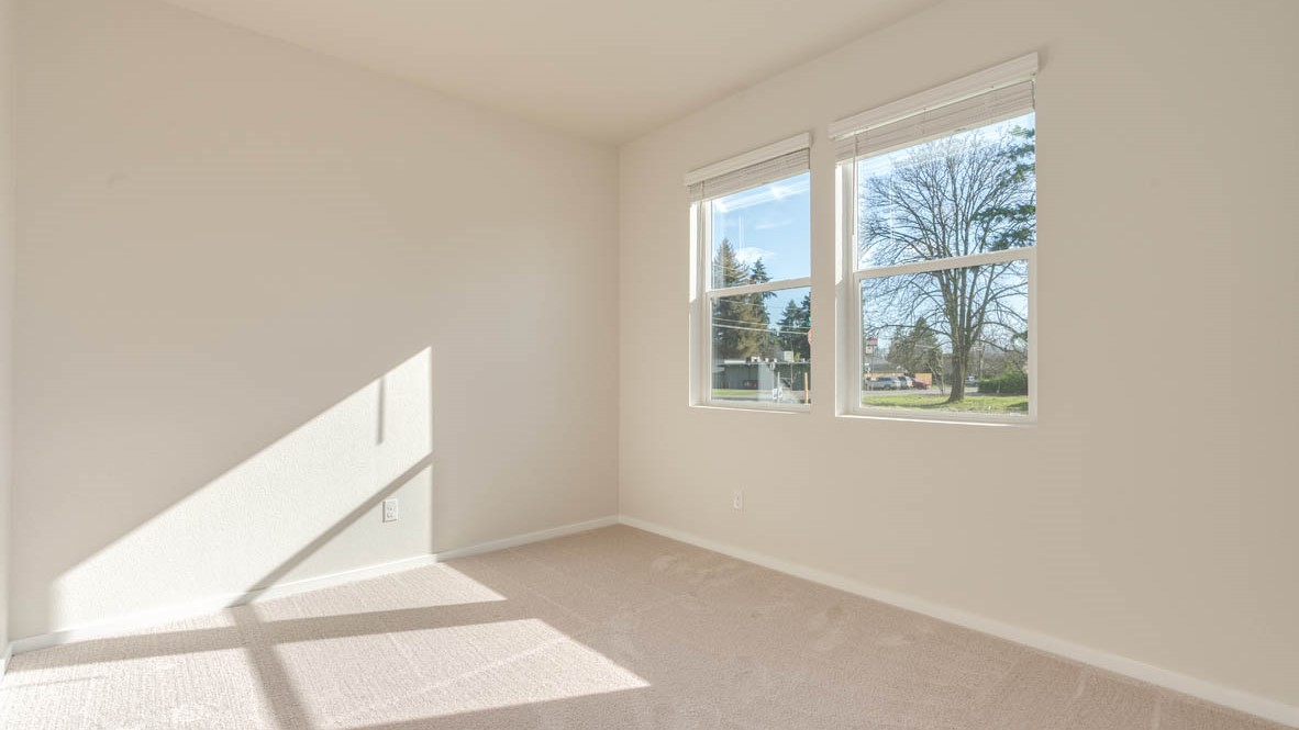 Eden Estates Den with carpeting and white walls, two windows