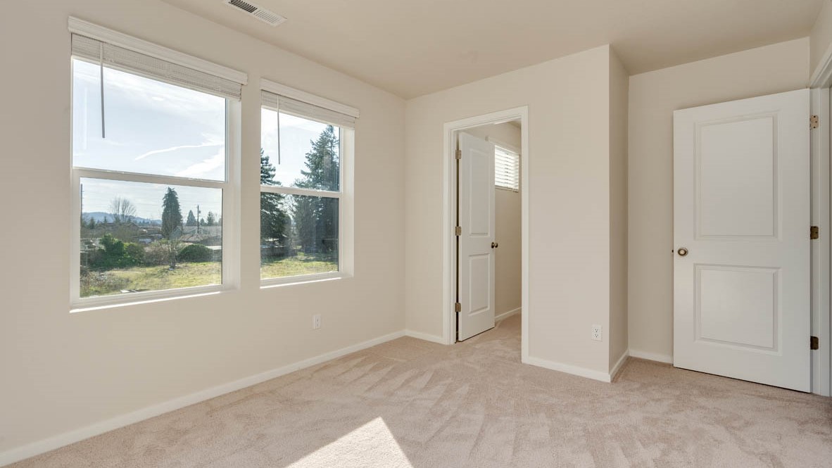 Eden Estates bedroom with carpet, window, and white walls