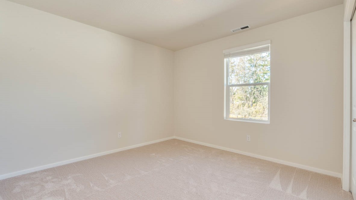 Eden Estates bedroom with carpet, window, and white walls