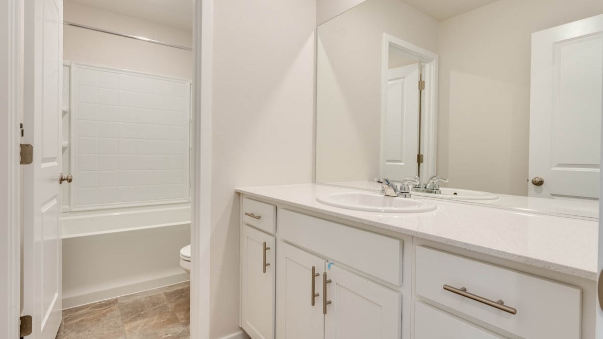 Eden estates bathroom with solid surface countertops, mirror, and cabinets