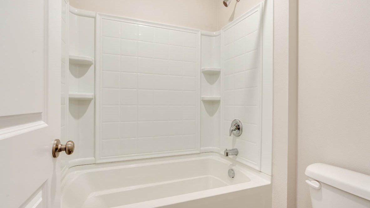 Eden Estates bathroom with toilet, and white shower tub