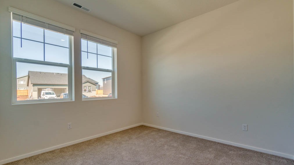 Eden Estates bedroom with carpet, window, and white walls