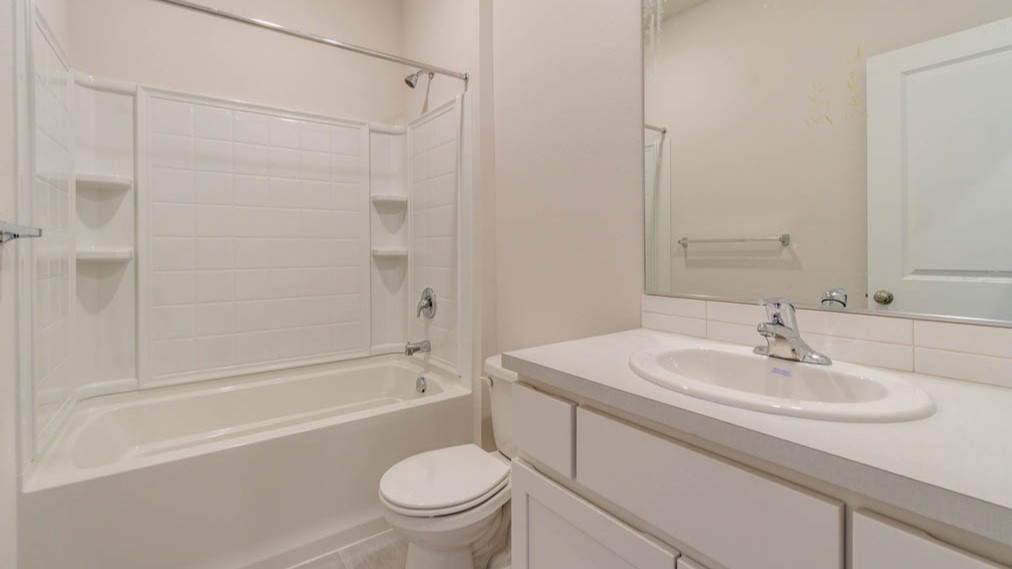 Eden estates bathroom with solid surface countertops, mirror, and cabinets