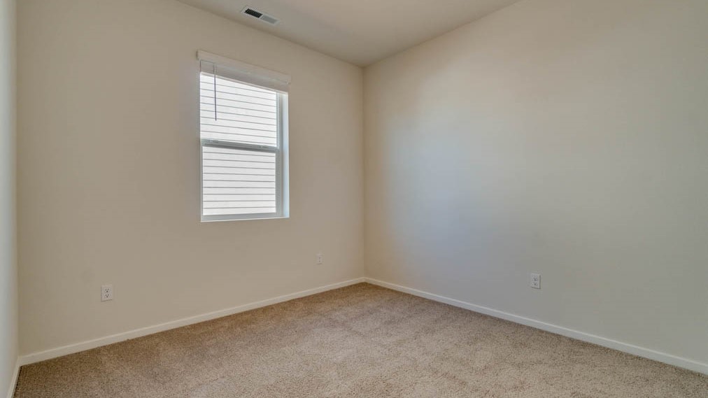 Eden Estates bedroom with carpet, window, and white walls