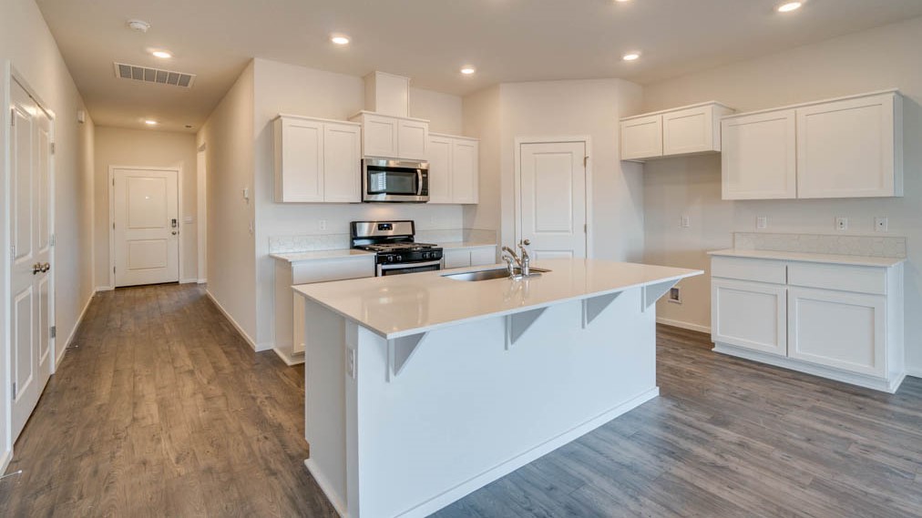 Eden Estates kitchen with laminate flooring, stainless steel appliances, cabinets, window, solid surface countertops