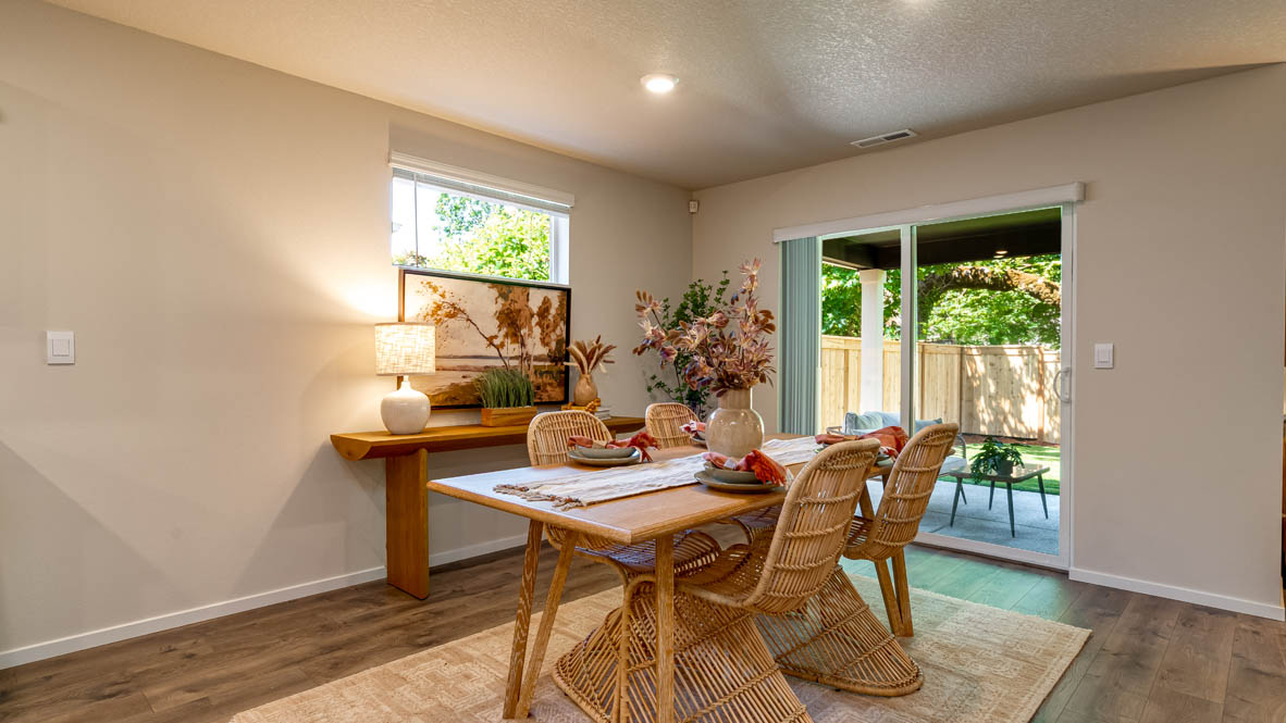 Eden Estates dining room with laminate flooring, windows, and the kitchen in the background