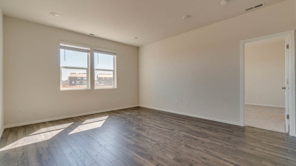 Eden Estates great room with fireplace, laminate flooring, and windows