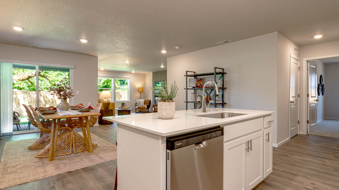 Eden Estates kitchen with laminate flooring, stainless steel appliances, cabinets, window, solid surface countertops