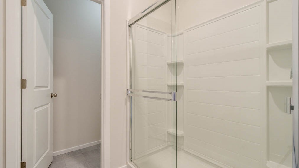 Eden Estates bathroom with toilet, and white shower tub