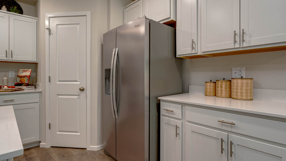 Eden Estates kitchen with laminate flooring, stainless steel appliances, cabinets, window, solid surface countertops