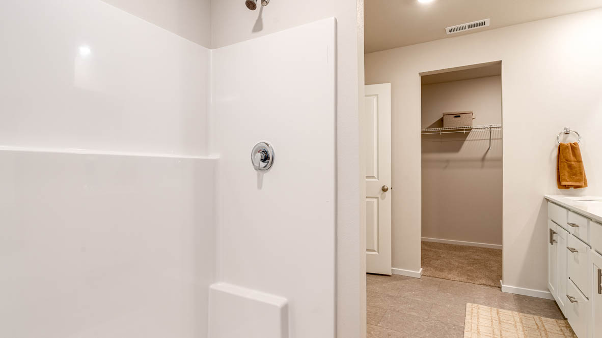 Eden Estates bathroom with toilet, and white shower tub