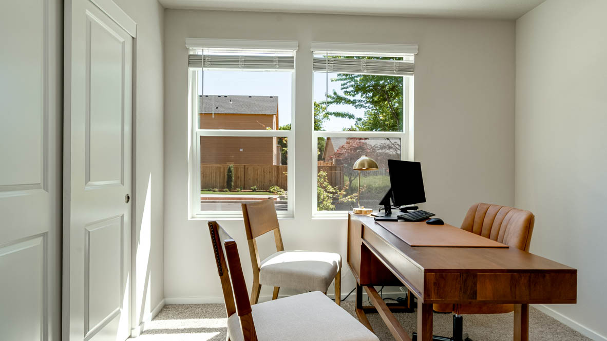 Eden Estates office with desk, chair, painting, and window