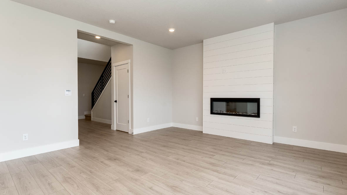Sorrento Estates great room with shiplap wall and electric fireplace