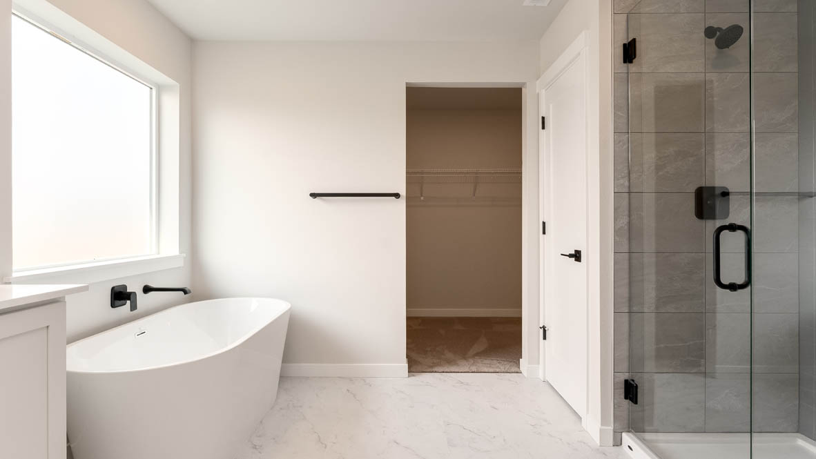 Sorrento Estates primary bathroom with free standing tub and walk in shower and walk in closet and double sink vanity