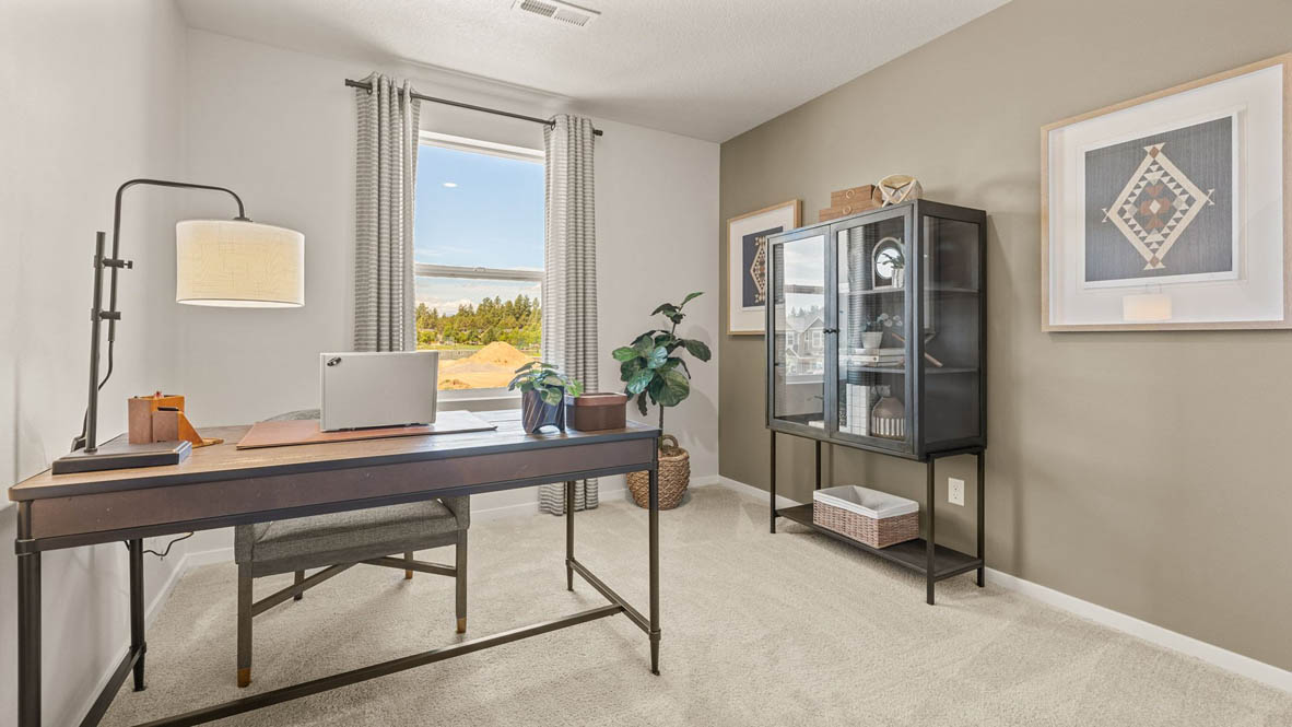 Sorrento Estates Den set up as an office with a desk, media cabinet, and plants