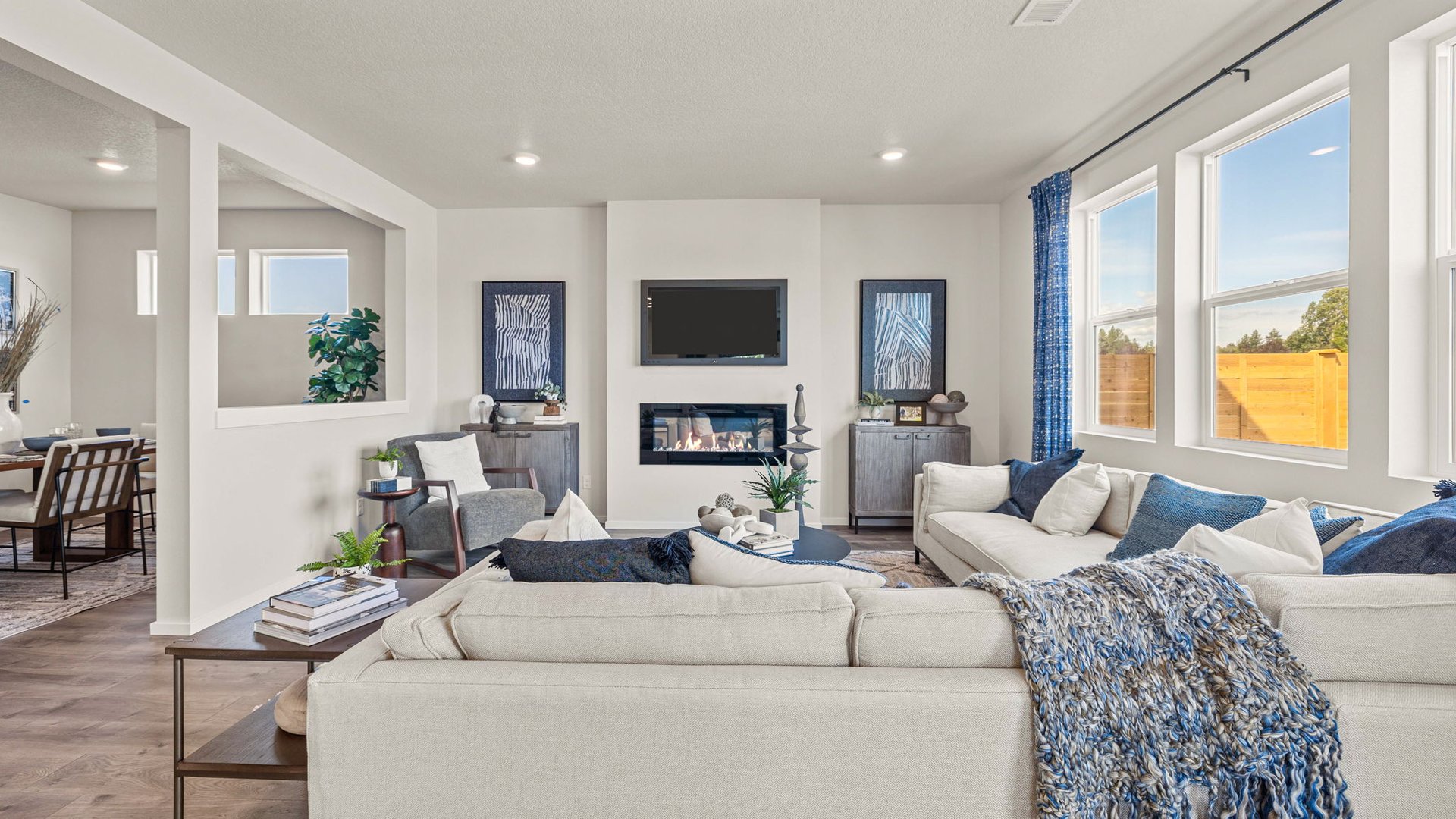 Monrovia Great room with L shaped sectional couch facing the fireplace and TV over an area rug with a coffee table and chair in the corner