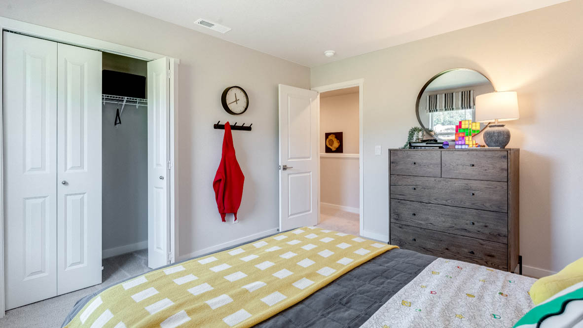 Sorrento Estates video game themed bedroom with a dark wooden dresser and white closet doors