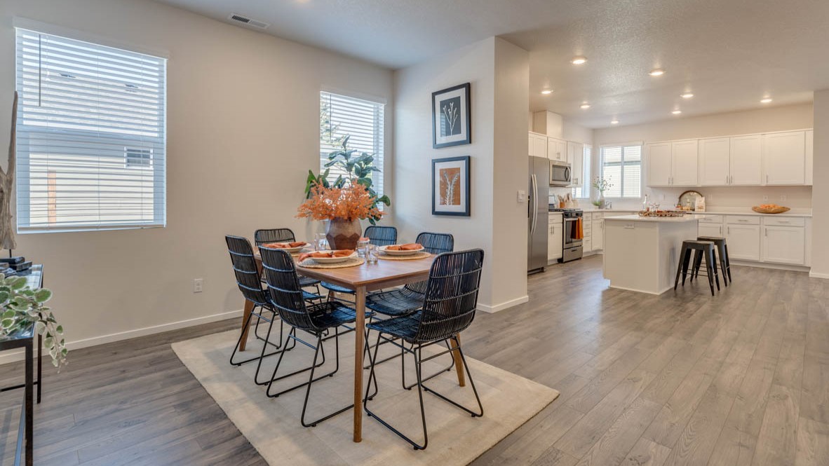 Sorrento Estates dining area with a dining table, four chairs, a rug, windows, and flooring