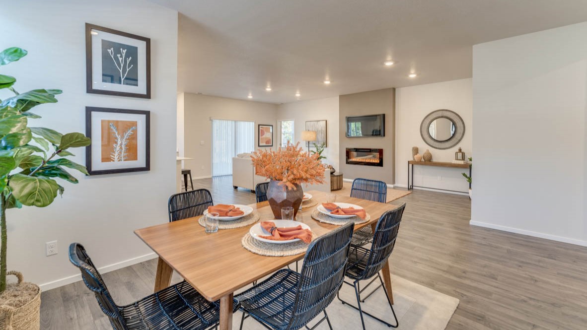 Sorrento Estates dining area with a dining table, four chairs, a rug, windows, and flooring