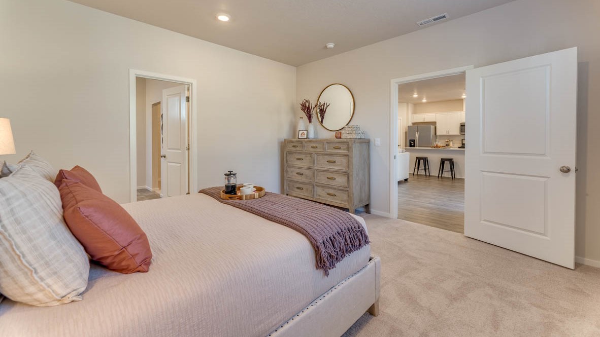 Sorrento Estates Primary bedroom with a bed, carpet, paintings, nightstand with a lamp, dresser with a lamp