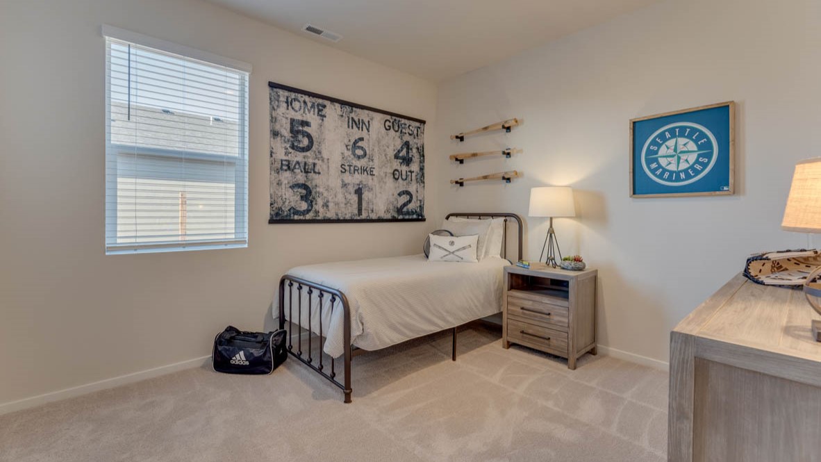 Sorrento Estates bedroom with a bed, carpet, paintings, nightstand with a lamp, dresser with a lamp