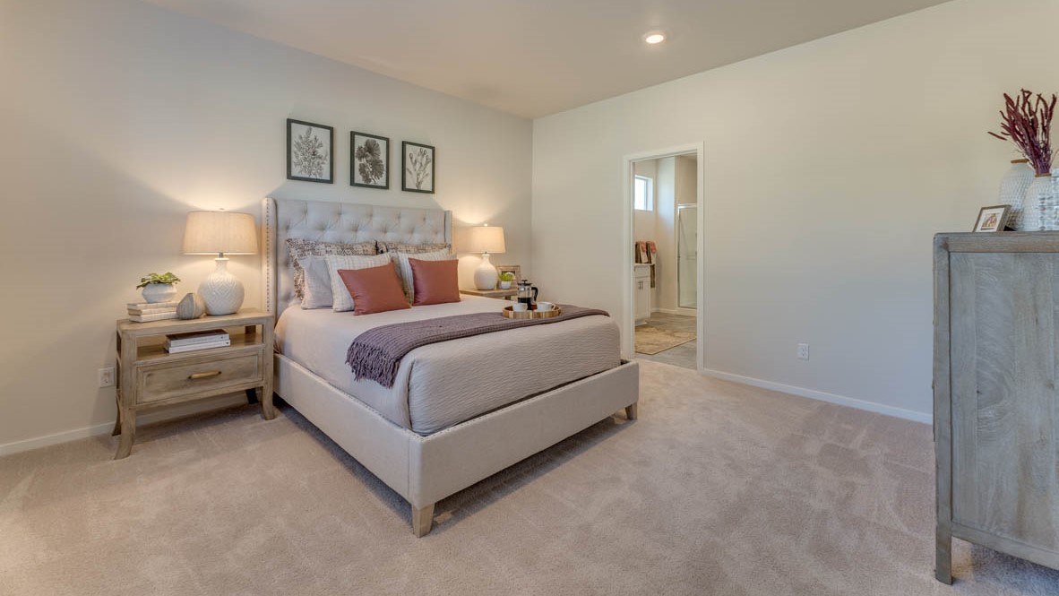 Sorrento Estates Primary bedroom with a bed, carpet, paintings, nightstand with a lamp, dresser with a lamp