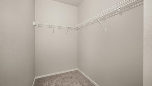 A walk in closet with wire shelving.
