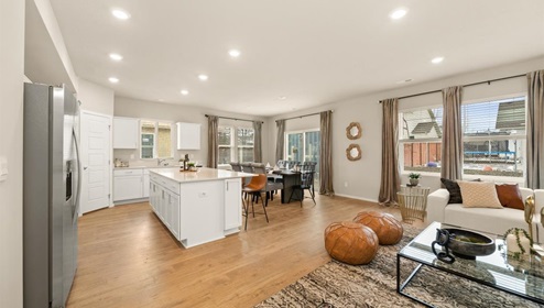 A living area with a large couch and a large patterned area rug.
