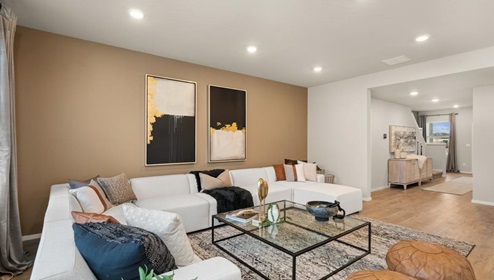 A living area with a large couch and a large patterned area rug.