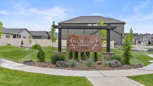 Photo of a brown community sign that reads "Elk Meadows Estates"
