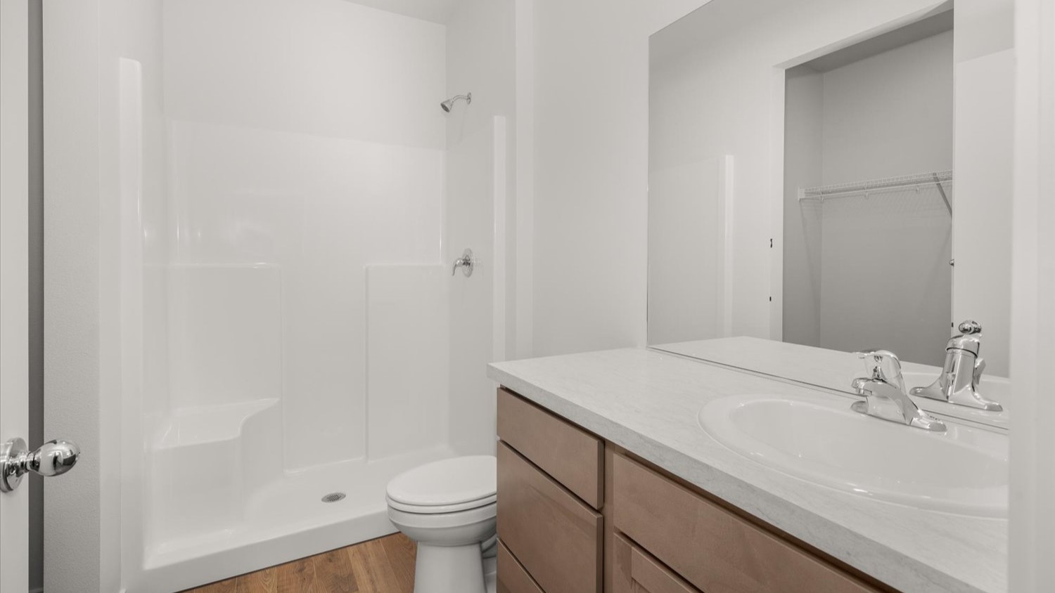 A bathroom with brown wood cabinets and white counters.