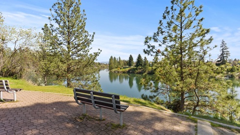 A view of a bench and the Spokane River from a nearby hiking trail.