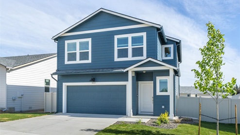 Photo of a two story home with blue siding and white accents.