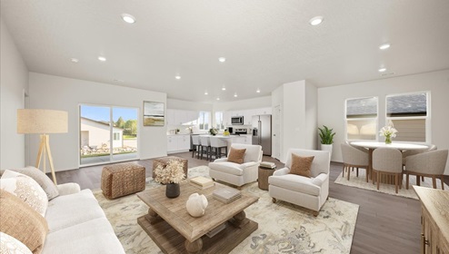 A living area with a light rug, white couch and accent chairs, a wood coffee table, and a view into the kitchen and dining areas.
