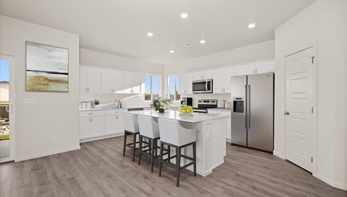 A kitchen with white cabinets and an island with a white countertop.