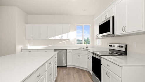 A kitchen with white cabinets and an island with a white countertop.