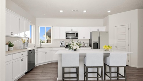 A kitchen with white cabinets and an island with a white countertop.