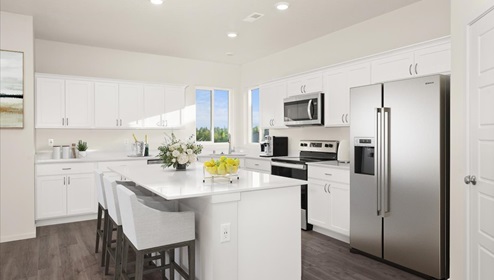 A kitchen with white cabinets and an island with a white countertop.
