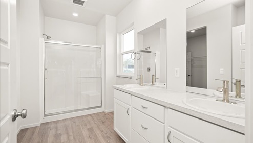 A bathroom with white cabinets and countertops.