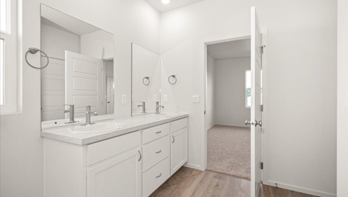 A bathroom with white cabinets and countertops.