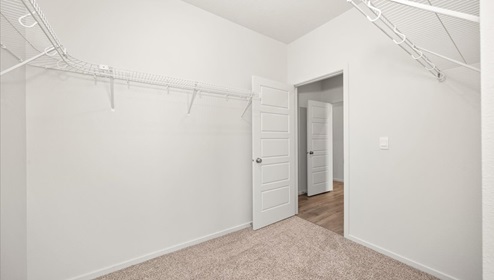 A walk in closet with wire shelving.