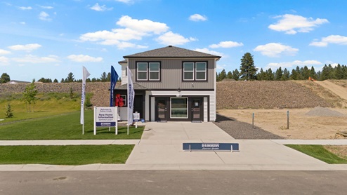 A front view of the Dalton Creek model home, a two story home with two toned grey and white siding and dark accents.
