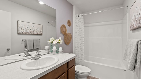 A bathroom with brown wooden cabinets and a light countertop.