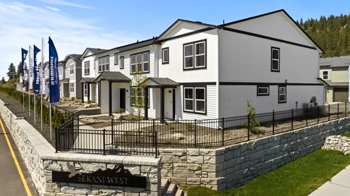 A row of townhomes with white siding and black accents.