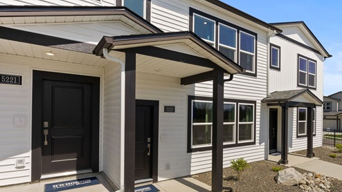 A row of townhomes with white siding and black accents.