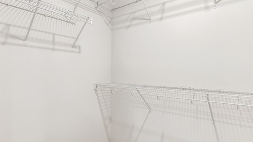 Close up of wire shelving from walk-in closet of primary bedroom suite of Windom floor plan