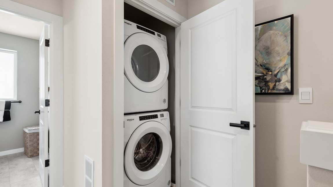 Stacking washer and dryer inside the laundry closet in the Addison model home at Cathcart Crossing